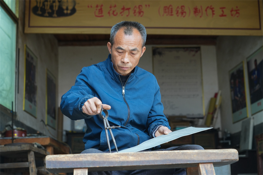 Inheritor passes on tin carving techniques in China's Jiangxi