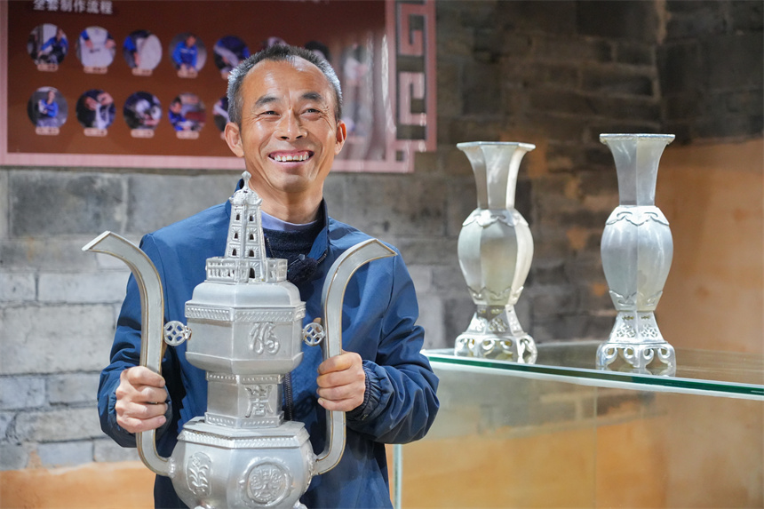 Inheritor passes on tin carving techniques in China's Jiangxi