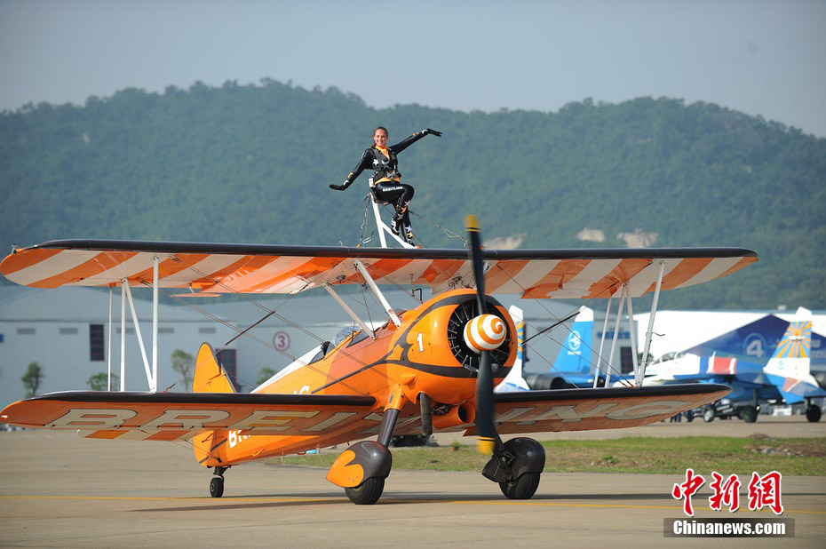 Photo taken on Nov. 11, 2012 shows the wingwalkers of Beritling Jet Tem, a famous European aerobatic team, putting on wonderful performance on the wings of biplaines during a test flight for the Airshow China 2012. The airshow kicked off on Tuesday morning in south China’s Zhuhai. (Photo/Chinanews.com)