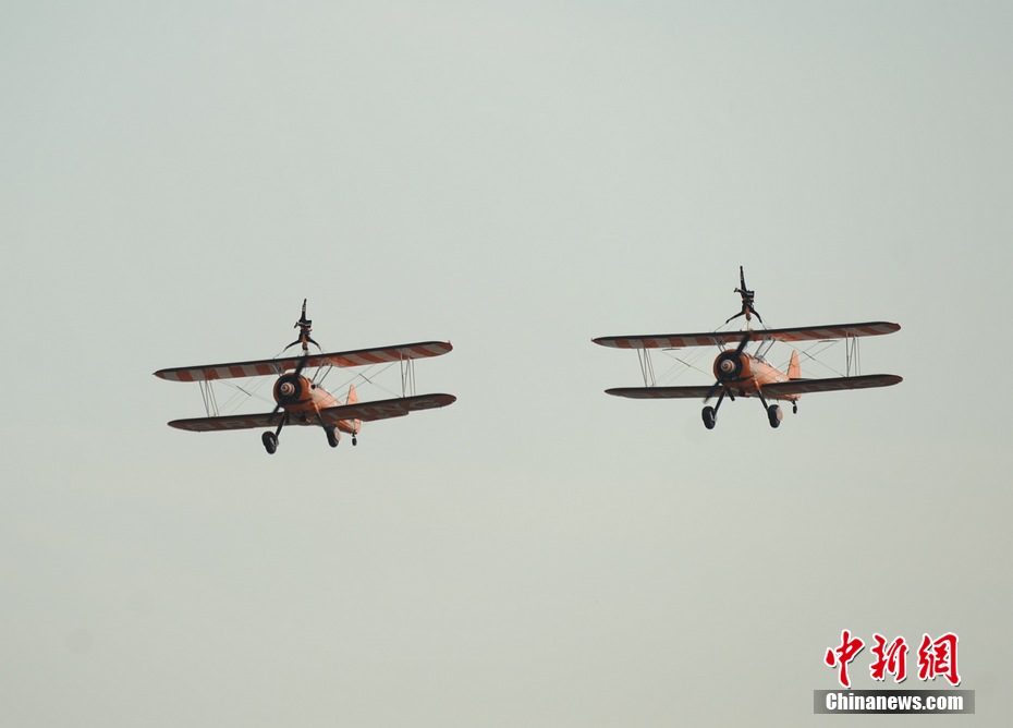 Photo taken on Nov. 11, 2012 shows the wingwalkers of Beritling Jet Tem, a famous European aerobatic team, putting on wonderful performance on the wings of biplaines during a test flight for the Airshow China 2012. The airshow kicked off on Tuesday morning in south China’s Zhuhai. (Photo/Chinanews.com)