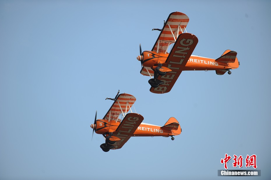 Photo taken on Nov. 11, 2012 shows the wingwalkers of Beritling Jet Tem, a famous European aerobatic team, putting on wonderful performance on the wings of biplaines during a test flight for the Airshow China 2012. The airshow kicked off on Tuesday morning in south China’s Zhuhai. (Photo/Chinanews.com)