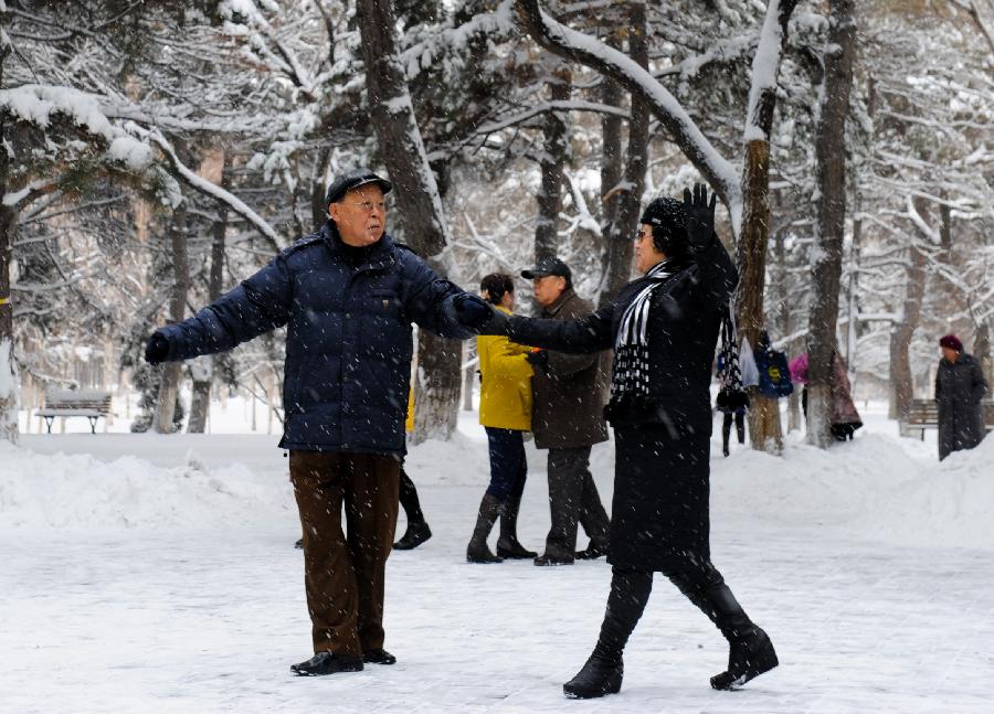 Citizens dance in a snow-covered yard of Nanhu Park in Changchun, capital of northeast China's Jilin Province, Nov. 13, 2012. The city witnessed a heavy snow since Monday. (Xinhua/Xu Chang) 