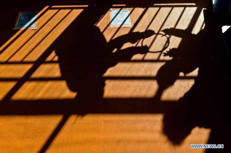 Photo taken on Nov. 19, 2012 shows the shadow of a teacher and a kid doing rehabilitation training in the An'an Autism Rehabilitation Center in Jinan, capital of east China's Shandong Province. The center has received over 2,000 children with autism for rehabilitation treatment since its foundation in 2006. More than one-third of the children went to normal kindergartens and schools after 10-14 months' training here. (Xinhua/Guo Xulei) 