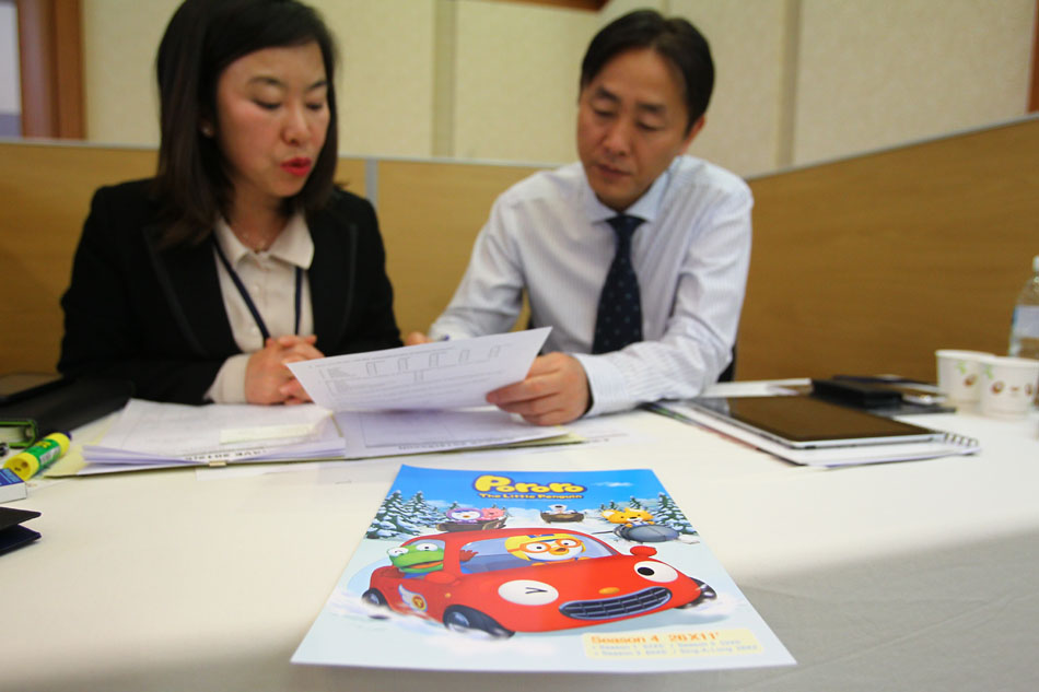 Wang Jin (R), discusses with his interpreter during an animation fair held in Seoul, South Korea, April 12, 2012. (Xinhua/Meng Chenguang)