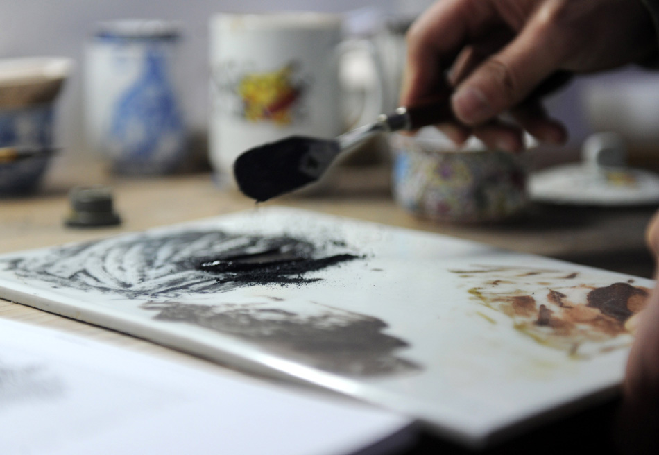 Liu Zhen mix the painting pigment in his studio at the Chengdexuan Porcelain Co.,Ltd, in Jingdezhen of east China's Jiangxi Province, March 8, 2012. (Xinhua/Zhou Ke)