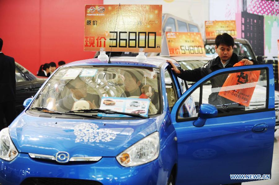 Visitors look at an economy car during the 2012 Harbin Autumn Automobile Exhibition in Harbin, capital of northeast China's Heilongjiang Province, Nov. 20, 2012. Economy cars presented on the week-long exhibition with a price under 100,000 yuan (about 16,030 U.S. dollars) attracted lots of attention. (Xinhua/Wang Jianwei)