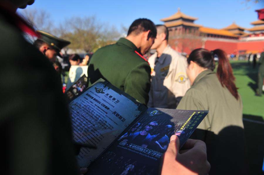 A veteran of Chinese national flag escort watches employment information in Beijing, capital of China, Nov. 23, 2012. More than 40 companies came to the escort to employ the demobilized veterans on Friday. (Xinhua/Liu Changlong) 