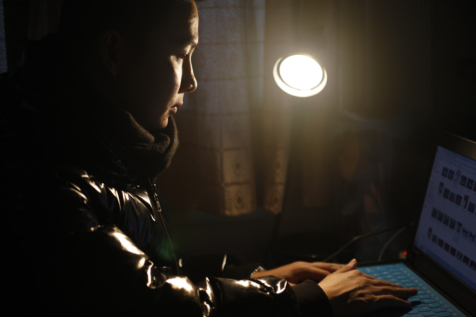 Zeng Jie surfs online in his apartment which he co-rent with a friend in Hangzhou, capital of east China's Zhejiang Province, Dec. 8, 2011. (Xinhua/Cui Xinyu)