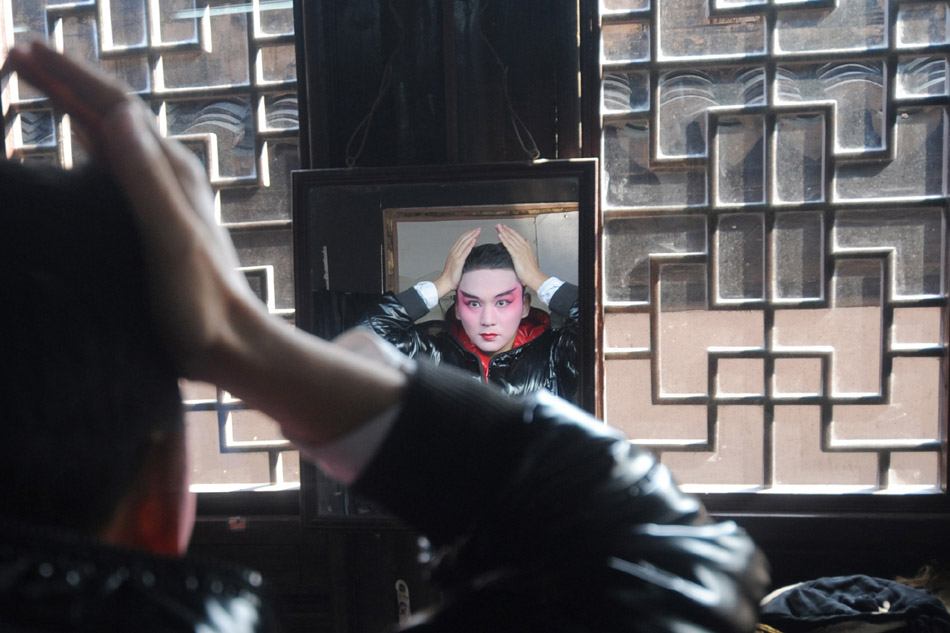 Zeng Jie is seen making up before a live performance in Zhouzhuang, east China's Zhejiang Province, Dec. 10, 2011.  (Xinhua/Han Chuanhao)