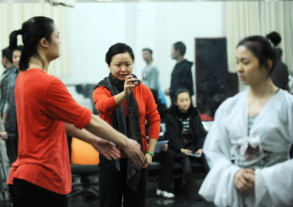 Director and choreographer Tong Ruirui (C) instructs performers during the rehearsal of the dance drama Goddess And The Dreamer in Zhengzhou, capital of central China's Henan Province, March 22, 2012. (Xinhua/Zhao Peng)