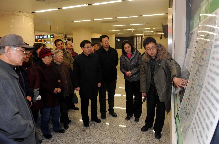 A manager (1st R) from Beijing Railway Transportation Construction and Administration Co., Ltd. briefs citizens on the construction of the northern section of Subway Line 9 in Beijing, capital of China, Nov. 26, 2012. The northern section of Beijing Subway Line 9, which operates between the National Library and Beijing West Station, is scheduled to open by the end of 2012. The southern section of the 16.45-km subway line is already in service since its opening on Dec. 31, 2011. (Xinhua/Gong Lei) 