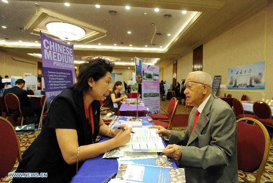 Exhibitors attend the "Chinese Universities Expo", held by the Chinese Embassy and the China Scholarship Council joint with the Chile's National Commission for Scientific and Technological Research (CONICYT), in Santiago, capital of Chile, on Nov. 26, 2012. The expo is held with the participation of 47 Chinese universities that will show their academic offerings and seek promote the interests of Chileans to study in China. (Xinhua/Jorge Villegas) 