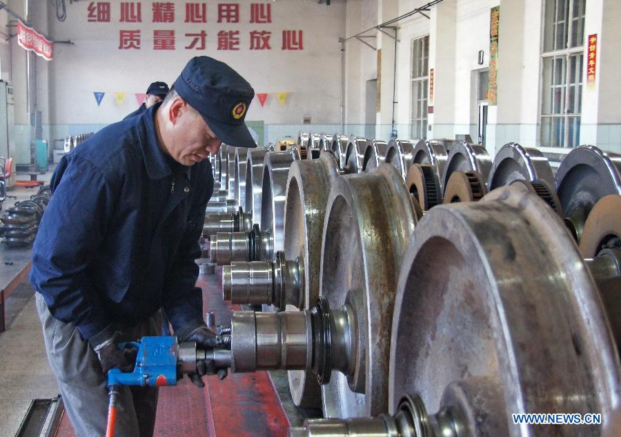 A worker of the Baotou vehicle section of the Hohhot Railway Bureau assembles wheel sets in Baotou, north China's Inner Mongolia Autonomous Region, Nov. 29, 2012. Facing the low temperatures, strong winds and snowfalls since winter, the Hohhot Railway Bureau has organized all its departments to guarantee the rail transport in winter, including activities like strengthening vehicle scheduling and security inspection during on-site operations. (Xinhua/Zhao Tingting)