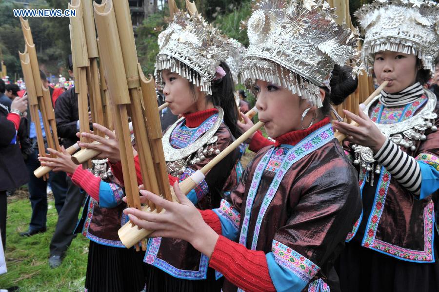 Women of the Dong ethnic group play the Sheng, a Chinese reed pipe wind instrument, during a celebration ceremony marking the 100th anniversary of the completion of Chengyang Fengshui Bridge held in Sanjiang Dong Autonomous County, south China's Guangxi Zhuang Autonomous Region, Dec. 1, 2012. (Xinhua/Lai Liusheng) 