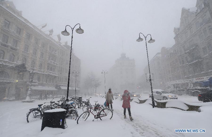 People walk in heavy snow in Stockholm, capital of Sweden on Dec. 5, 2012. Stockholm's traffic was affected by the bad weather on Wednesday. (Xinhua/Wu Wei) 