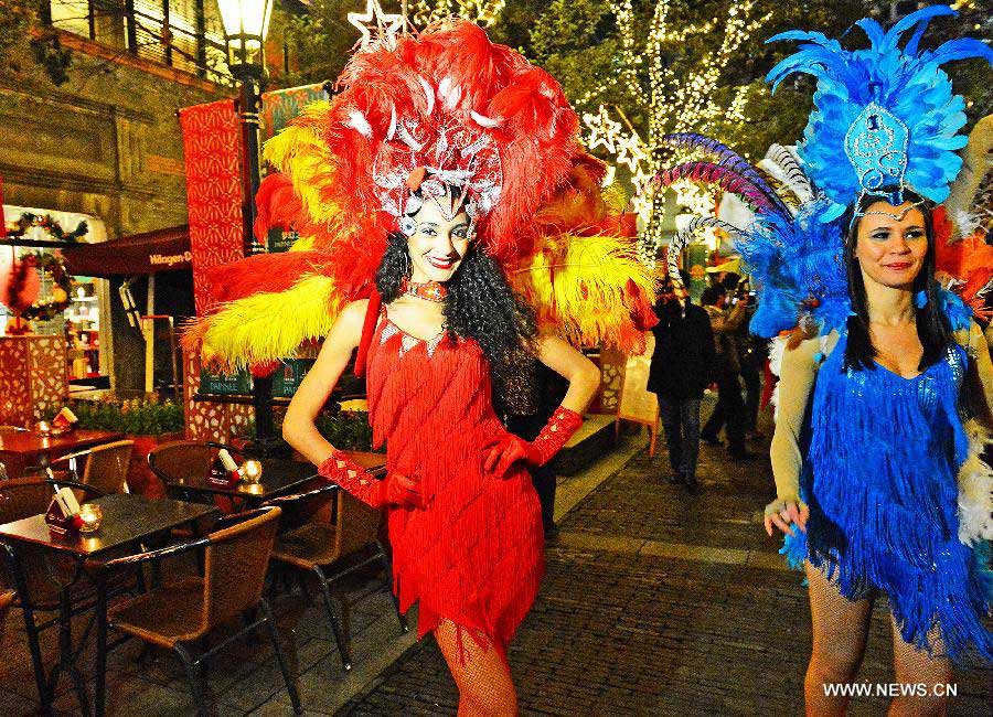 Foreign performers pose for photos during a lighting ceremony celebrating the upcoming Christmas and new year at Shanghai Xintiandi, one of the city's tourist landmarks, in Shanghai, east China, Dec. 5, 2012. (Xinhua/Guo Changyao)  