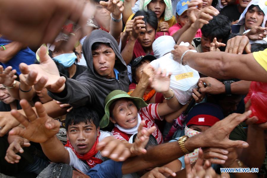 Typhoon-affected residents wait for relief food in a heavily damaged town of New Bataan of Compostela Valley Province, the Philippines, Dec. 9, 2012. The death toll from Typhoon Bopha (locally known as Pablo) has climbed to 540 and 827 others are still missing, official statistics released Sunday showed. (Xinhua/JEMA)  