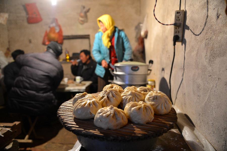 Seasonal reed reapers prepare dinner in Zhanhua County, east China's Shandong Province, Dec. 9, 2012. More than 2000 seasonal workers gathered in the wetland area of the Yellow River Delta from November to harvest reed for extra incomes. The annual output of the reed planting industry in the delta area has reached more than 70 million RMB (11.21 million U.S. dollars) in recent years. (Xinhua/Zhu Zheng)