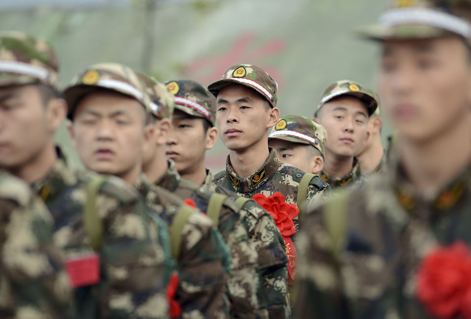 New recruits for the People's Liberation Army wait for the train to leave at a train station. The People's Liberation Army has launched its annual winter conscription this year. (Xinhua)