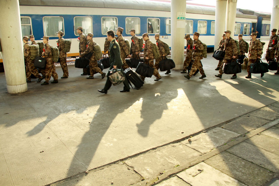 New recruits for the People's Liberation Army wait for the train to leave at a train station. The People's Liberation Army has launched its annual winter conscription this year. (Xinhua)