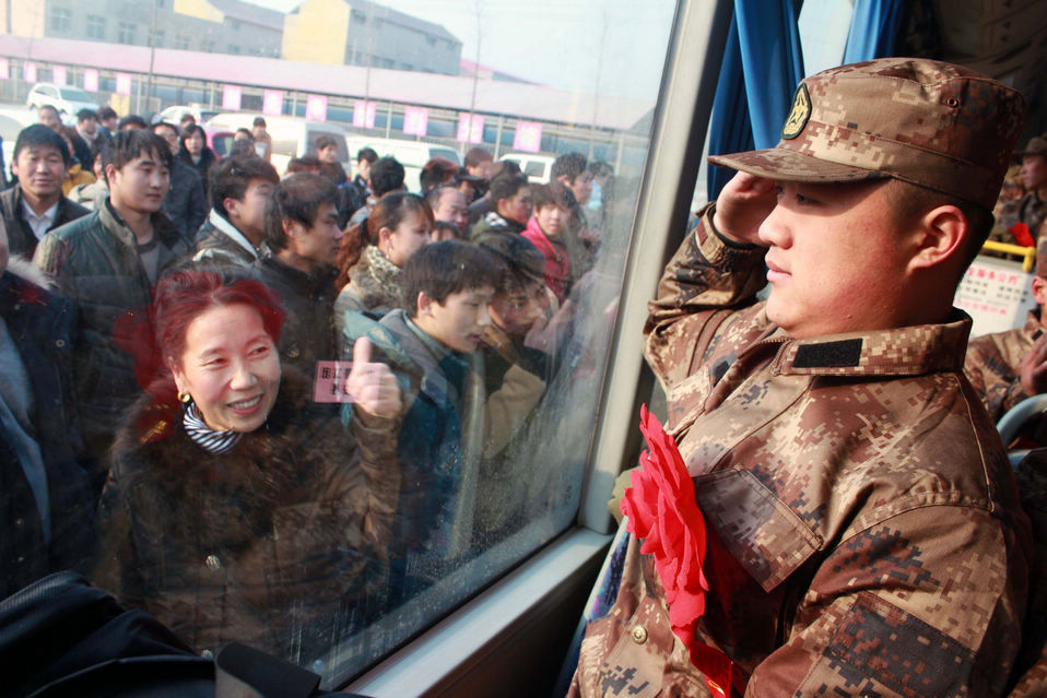 New recruits for the People's Liberation Army wait for the train to leave at a train station. The People's Liberation Army has launched its annual winter conscription this year. (Xinhua)