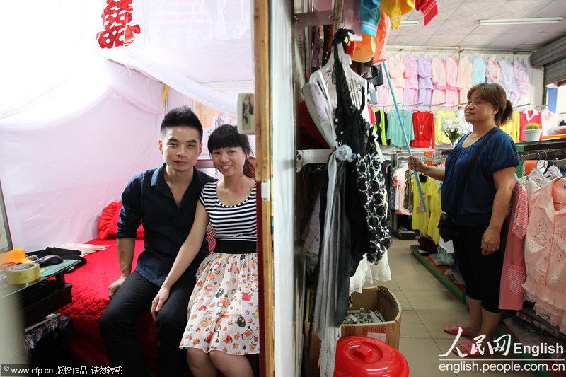 Zhang and his wife are in their bridal chamber, a small compartment in the clothing store of Zhang's parents which is 3.1 meters wide and 1.5 meters long, separated by splints and cardboards. (CFP)