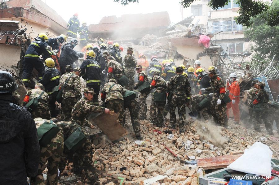 Rescuers clear up debris at a collapsed residential building in Ningbo, east China's Zhejiang Province, Dec. 16, 2012. The Five-story residential building collapsed around Sunday noon. The number of casualties is unknown. (Xinhua)