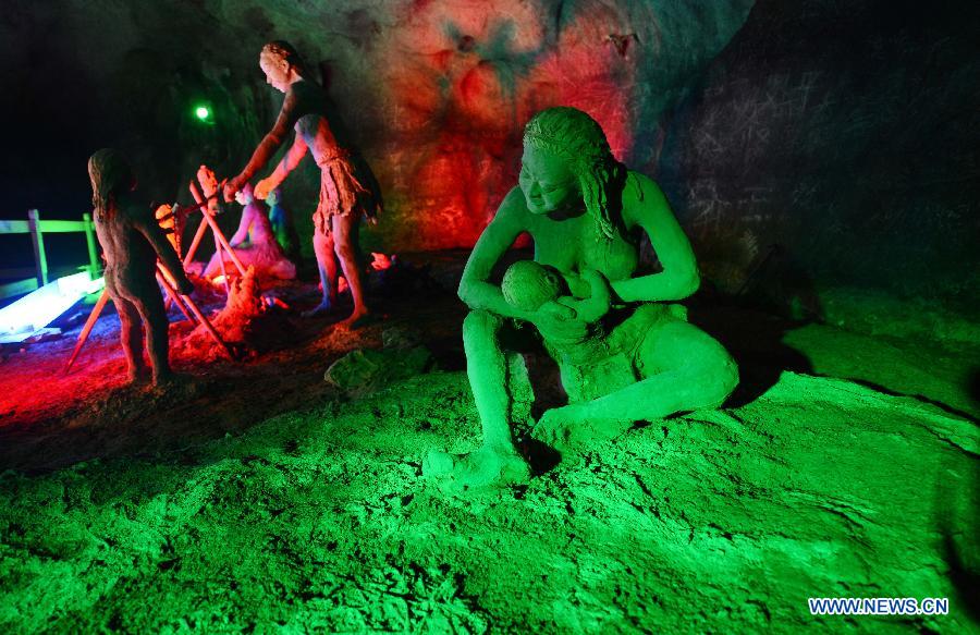 Photo shows the sculptures imitating ancient people's life at the Xianren Cave in Dayuan Township of Wannian County, east China's Jiangxi Province. Xianren Cave is the location for historically important finds of prehistoric pottery sherds and rice remains. (Xinhua/Zhou Ke) 