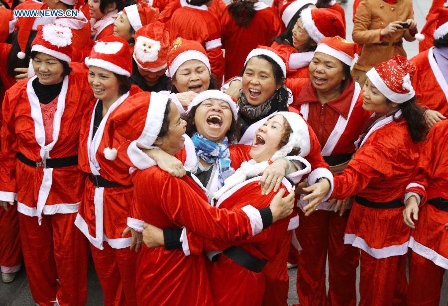 Members of the "Laughter Yoga" club participate in an event called "Christmas Smile" near the Hoan Kiem Lake in Hanoi, Vietnam, on Dec. 23, 2012. (Xinhua/Ho Nhu Y) 