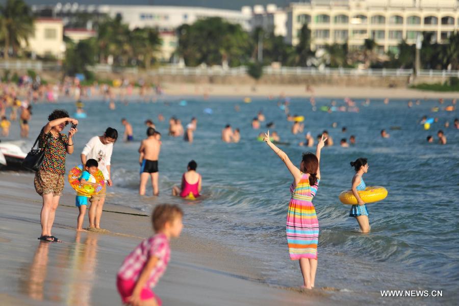 Tourists enjoy themselves at a beach in Sanya, a popular winter toursim destination in south China's Hainan Province, Dec. 27, 2012. (Xinhua/Hou Jiansen)