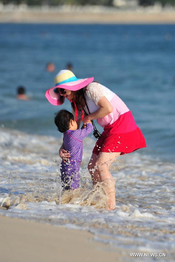 Tourists enjoy themselves at a beach in Sanya, a popular winter toursim destination in south China's Hainan Province, Dec. 27, 2012. (Xinhua/Hou Jiansen) 