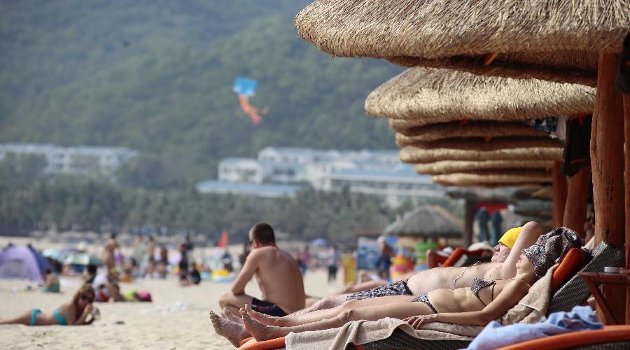 Tourists enjoy sunbath at a beach in Sanya, a popular winter tourism destination in south China's Hainan Province, Jan. 5, 2013. (Xinhua/Chen Wenwu)