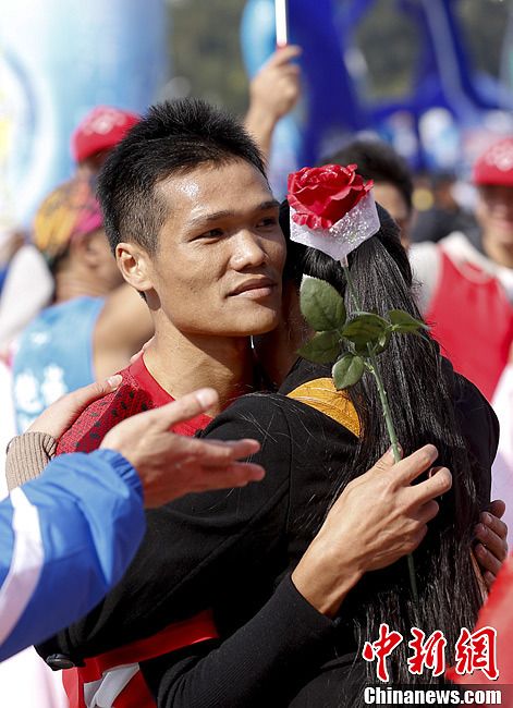 A man proposes to his girlfriend after finishing entire journey of 11th Xiamen International Marathon on Saturday morning. (Chinanews/ Du Yang)