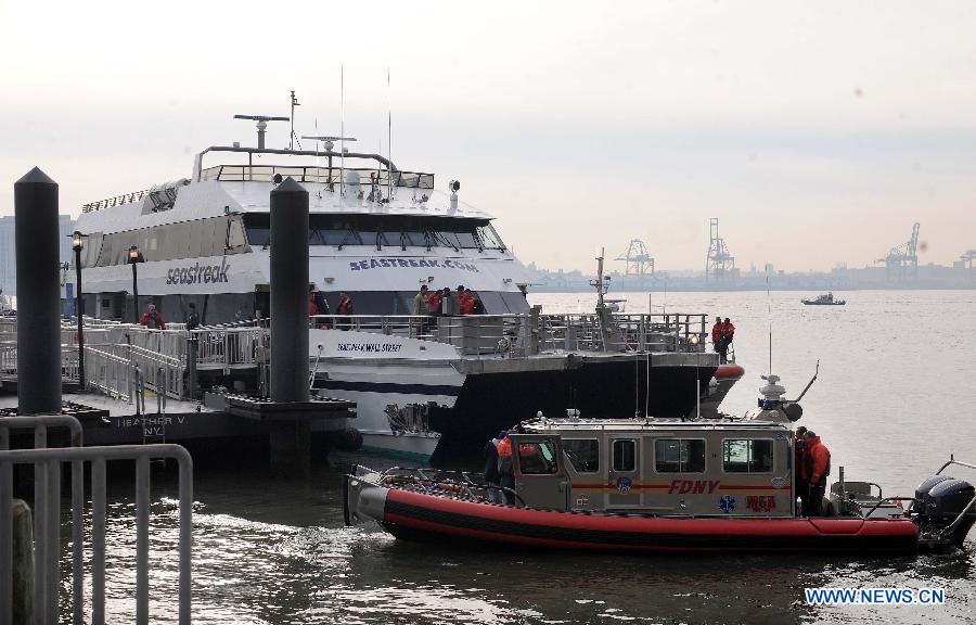 Rescue teams work at the accident site where a ferry boat crashed into Pier 11 in lower Manhattan, New York, the United States, on Jan. 9, 2013. A high-speed ferry loaded with hundreds of commuters from New Jersey crashed into a dock near Wall Street on Wednesday during the morning rush hour, injuring 57 people. (Xinhua/Shen Hong)