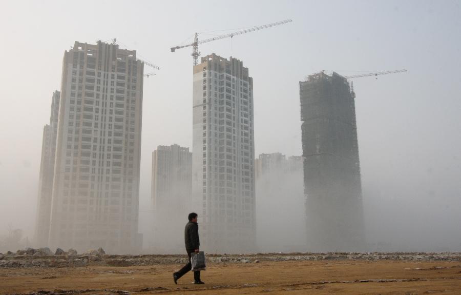 A man walks on a fog-shrouded road in Lianyungang City, east China's JIangsu Province, Jan. 13, 2013. Dense fog on Sunday hit China's east and central regions from the northeast to the south, causing serious air pollution. (Xinhua/Geng Yuhe) 