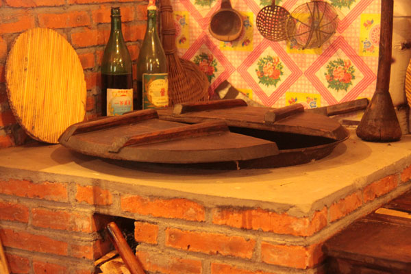 This photo on December 20, 2012, shows a cooking table in a house made of snow, which contains a collection of local rural furniture, daily articles and hunting products in Harbin, northeast China's Heilongjiang Province. (CRIENGLISH.com)