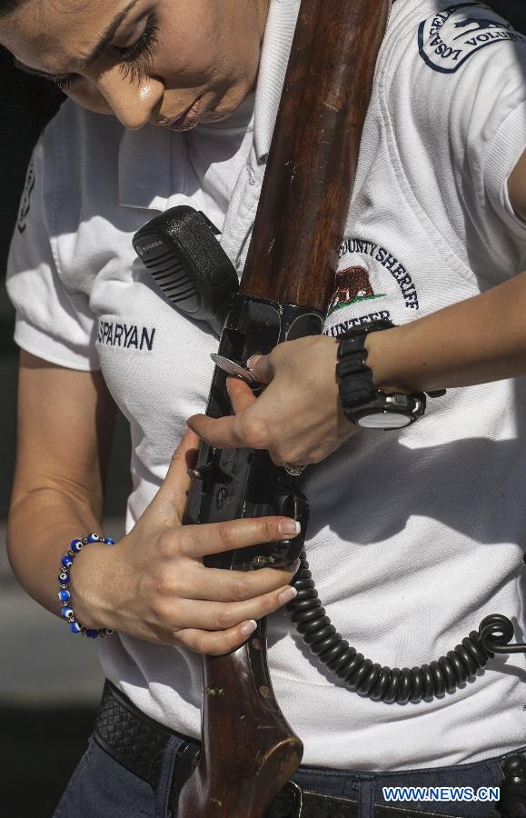 A Los Angeles County Sheriff's deputy checks a reclaimed pistol during a "Gifts For Guns" exchange program in Los Angeles, California, the United States, Jan. 21, 2013. People can turn in a firearm and receive a gift card of 200 U.S. dollars for an assault weapon, 100 U.S. dollars for a handgun, and 50 U.S. dollars for a shotgun. (Xinhua/Zhao Hanrong)  