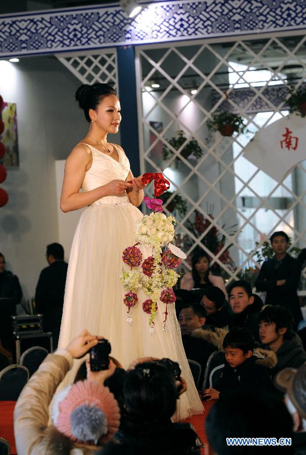 A model presents floral designs during the Flower Fair in Nanjing, capital of east China's Jiangsu Province, Jan. 25, 2013. (Xinhua/Sun Can)