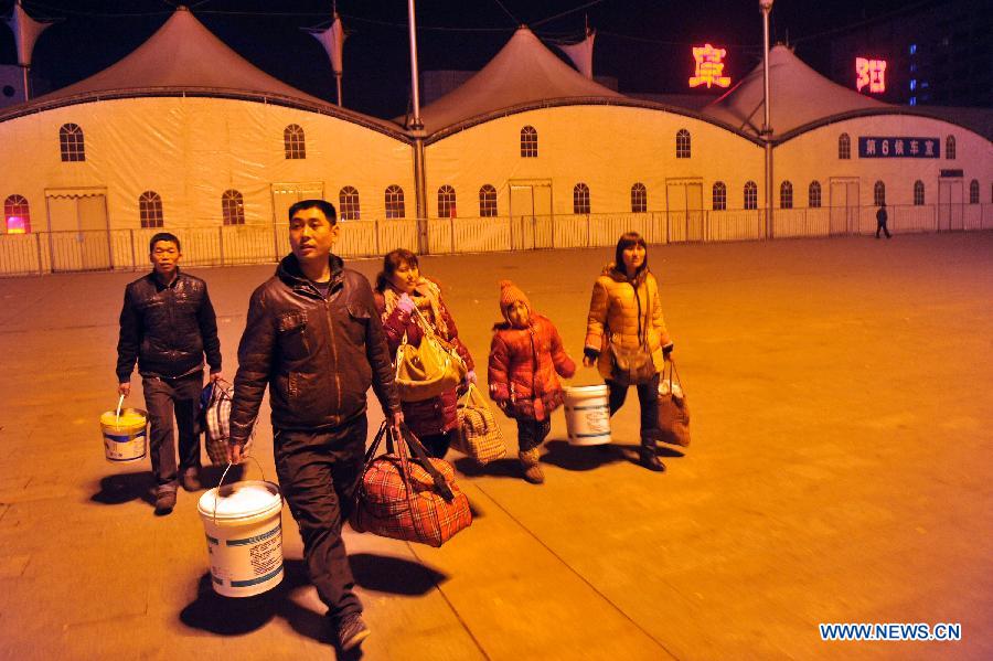 Liu Chuantao (front) and his relatives walk on the square of Fuyang Railway Station after getting off a train in Fuyang of east China's Anhui Province, Jan. 29 , 2013. (Xinhua/Huang Zongzhi) 