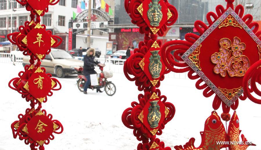 A woman rides on snow-covered road in Yongqing County of Langfang City, north China's Hebei Province, Feb. 5, 2013. (Xinhua/Zhang Yuyu) 