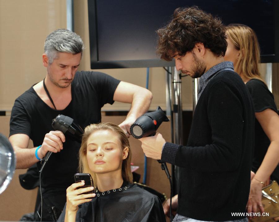 Stylists make hair for a model at the backstage before the presentation of Ralph Lauren 2013 Fall collections of the Mercedes-Benz Fashion Week in New York, Feb. 14, 2013. (Xinhua/Deng Jian)