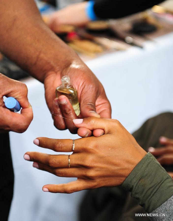 A stylist manicures the nails of a model at the backstage before the presentation of Ralph Lauren 2013 Fall collections of the Mercedes-Benz Fashion Week in New York, Feb. 14, 2013. (Xinhua/Deng Jian)