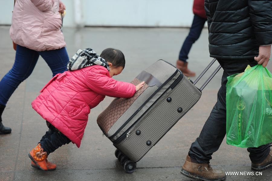 A child and her parents make their way at the Guiyang Railway Station in Guiyang, capital of southwest China's Guizhou Province, Feb. 17, 2013. When the Spring Festival holiday comes to an end, migrant workers start to leave their hometowns in Guizhou for job opportunities in China's more affluent coastal provinces. Many have to take their children with them. (Xinhua/Liu Xu)