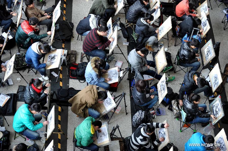 Candidates of Shandong University of Art and Desgin sit for painting examination at Jinan Shungeng International Exhibition Center in Jinan, capital of east China's Shandong Province, Feb. 20, 2013. More than 100,000 students applied for the entrance examination of China's art colleges in Shandong Province this year, up about 10 percent as compared to the number of last year. (Xinhua/Xu Suhui) 