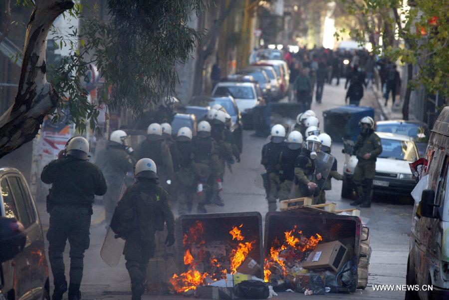 Demonstrators clash with riot police in central Athens, Greece, Feb. 20, 2013. A 24-hour general strike was organized by the two largest confederations of private sector workers (G.S.E.E.) and public sector employees (A.D.E.D.Y.) against the harsh and ineffective austerity measures, the sharp rise of unemployment and the government's plans to limit the labor unions' right to strike. (Xinhua/Marios Lolos) 