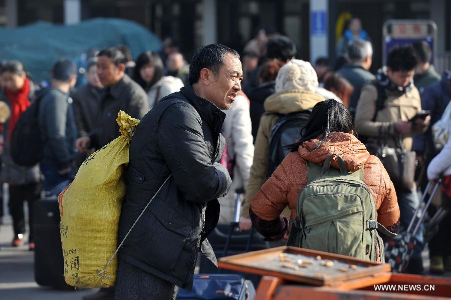 Passengers are seen carring their luggage on the square of the train station in Taiyuan, capital of north China's Shanxi Province, Feb. 21, 2013. Many people started their trips back to their working places after the Spring Festival holiday in recent days. (Xinhua/Zhan Yan) 