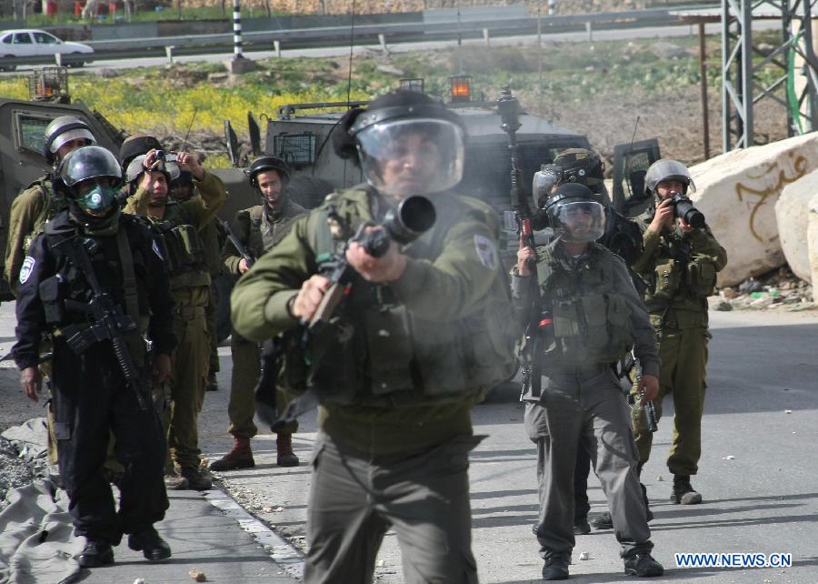 Israeli soldiers fire tear gas towards Palestinian protestor during clashes erupted in protest against the death of the Palestinian prisoner Arafat Jaradat in Asir town near the West Bank city of Hebron on Feb. 24, 2013. Thousands of Palestinian prisoners in Israeli jails rejected meals on Sunday to protest against an inmate's death a day earlier, local media reported. (Xinhua/Mamoun Wazwaz)