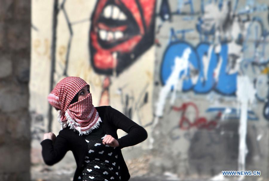 A female Palestinian protester throws stones at Israeli soldiers during clashes in the West Bank city of Bethlehem on Feb. 25, 2013. (Xinhua/Luay Sababa) 