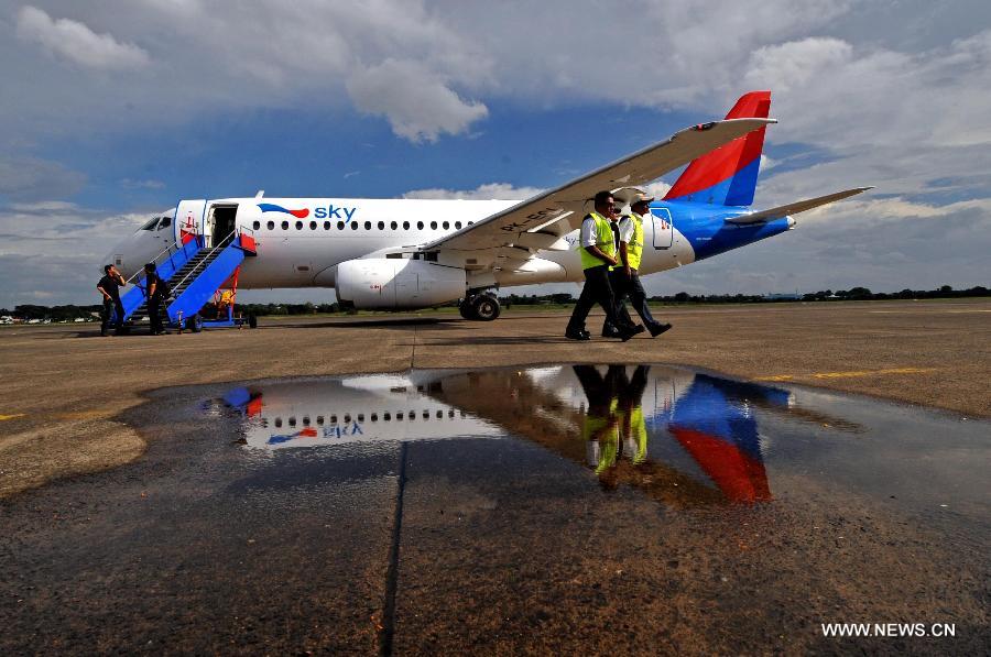 People walk past a Russian-made commercial plane Sukhoi Super Jet 100 (SSJ 100) at Halim Perdana Kusuma Airport in Jakarta, Indonesia, Feb. 28, 2013. An Indonesian airlines firm, Sky Aviation, received on Wednesday the initial delivery of SSJ 100, expecting five to join the fleet by the end of this year. (Xinhua/Agung Kuncahya B.) 