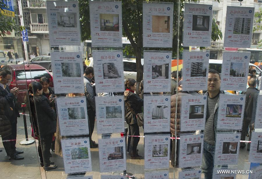 A citizen looks through secondhand housing information outside a real estate agency in Chongqing, southwest China, March 6, 2013. Secondhand housing transaction surges in Chongqing these days as buyers and sellers are rushing to catch the "last bus" and complete their deals before the new measures are fully implemented. According to the statement from the State Council, homeowners selling property will have to pay a capital gains tax of 20 percent of the profit they make on the transaction. Homeowners were previously taxed 1 percent to 2 percent of the total sale price. (Xinhua/Chen Cheng) 